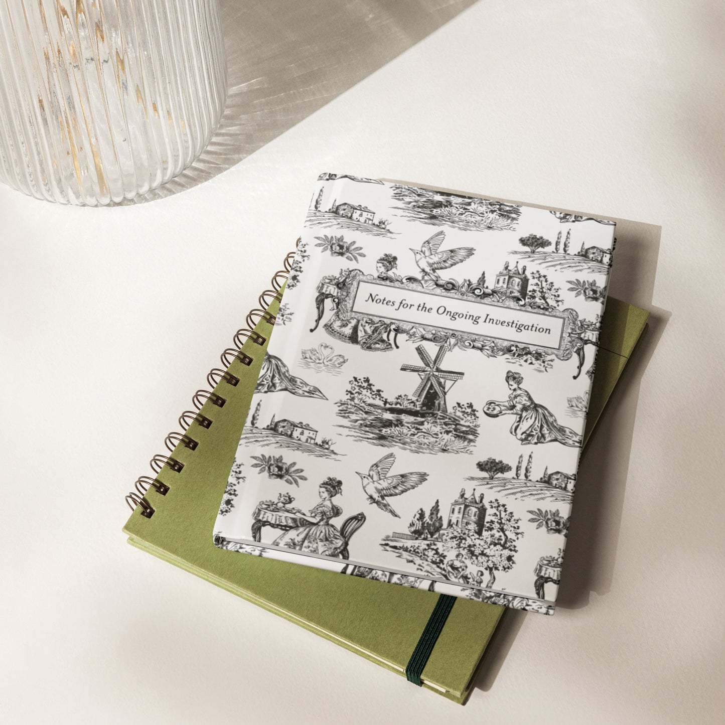 Hardcover journal with black-and-white French toile pattern and framed title “Notes for the Ongoing Investigation”