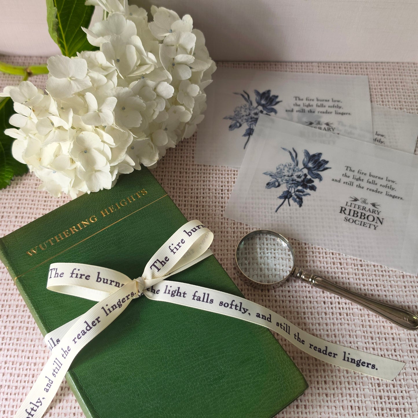 Literary quote ribbon styled with vintage book, vellum packaging, and personalized ribbon cards