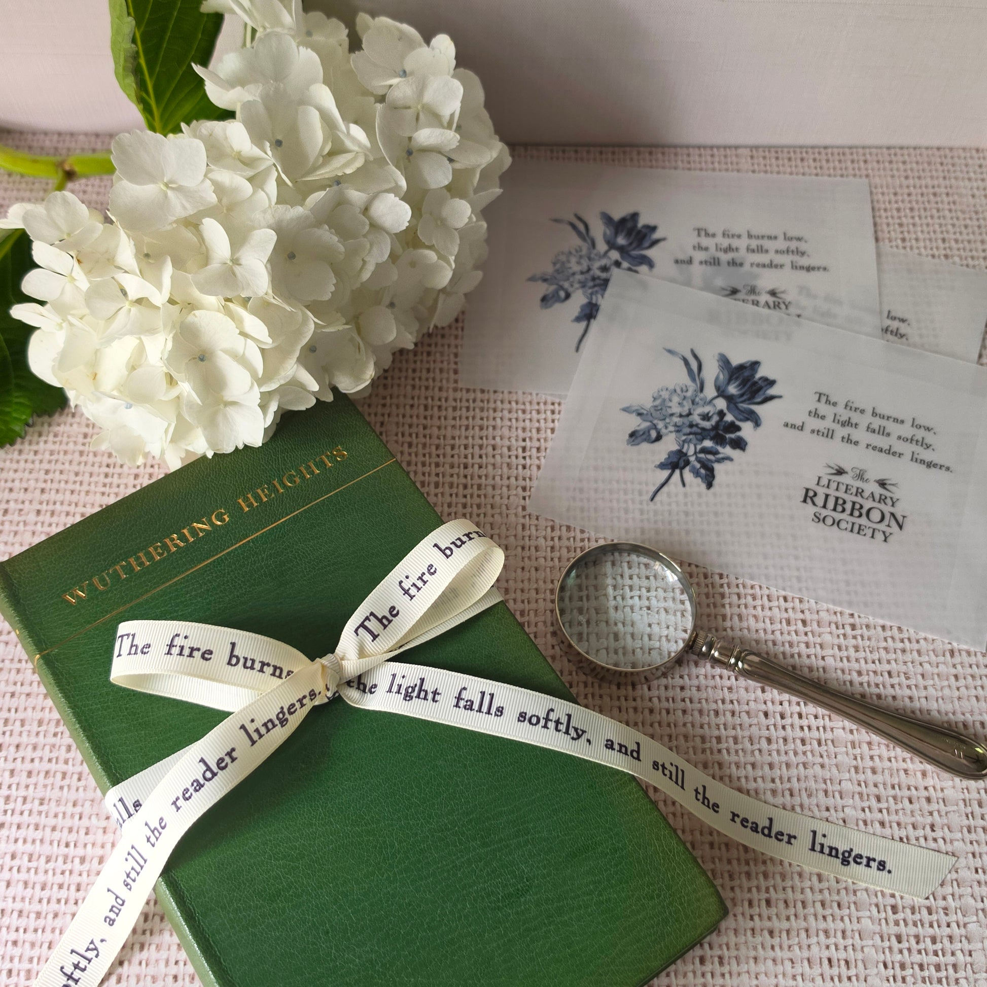 Literary quote ribbon styled with vintage book, vellum packaging, and personalized ribbon cards