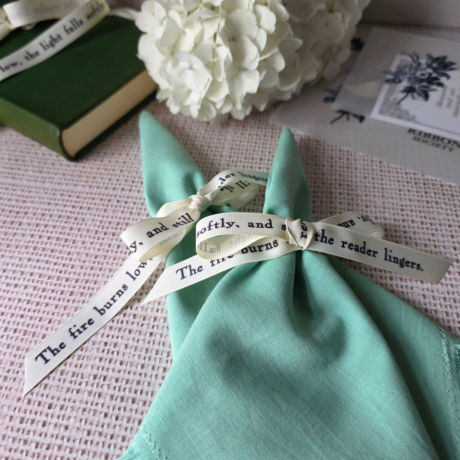 Printed literary ribbon styled as elegant table setting ribbon on linen napkin