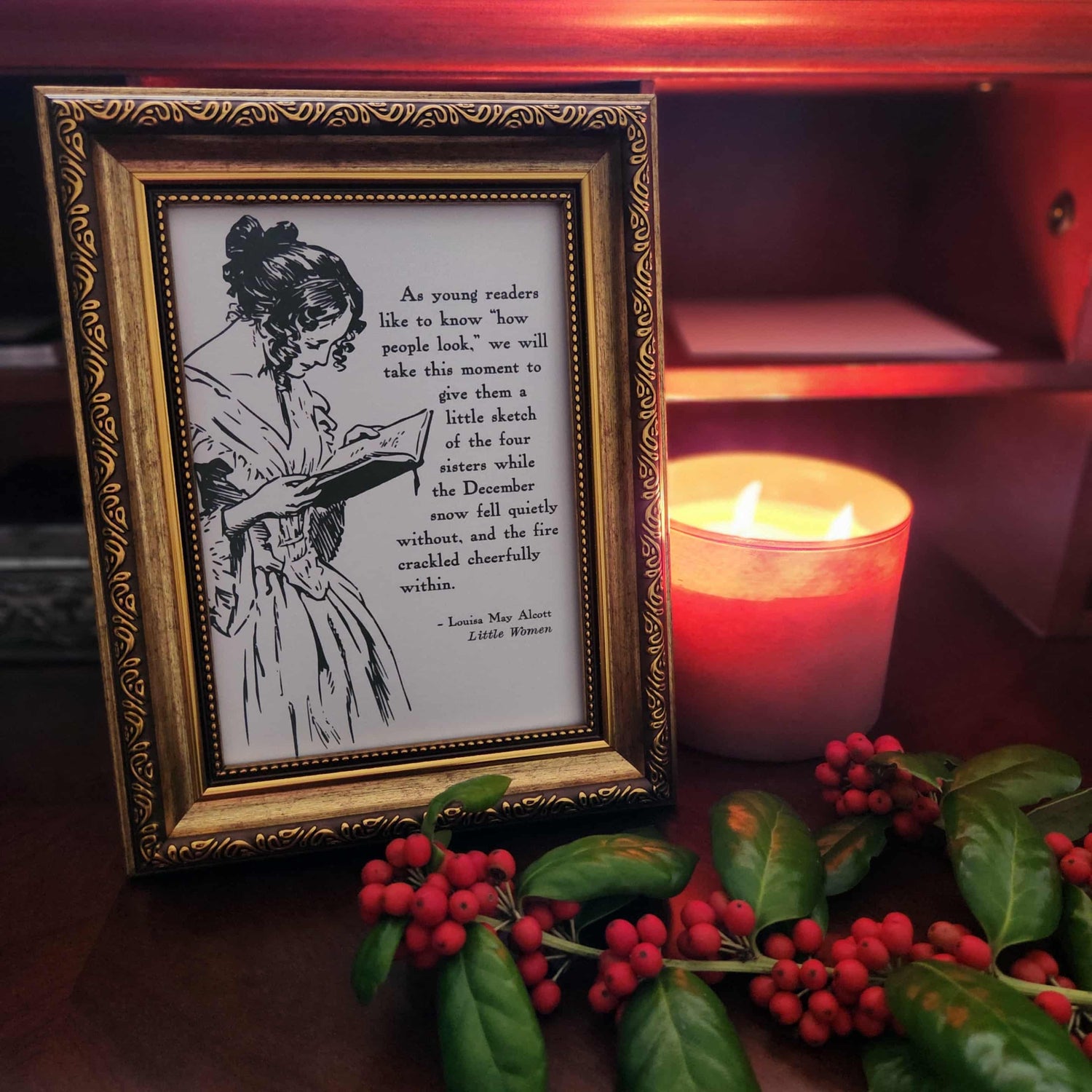 Framed art print from The Prose & Post Society with holly design and quote from Little Women on a wooden surface with holly berries.