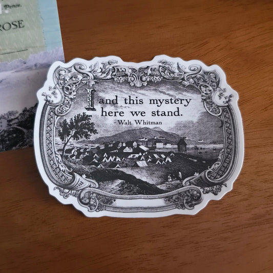 Die-cut sticker with quote from Walt Whitman, on a wooden table. 