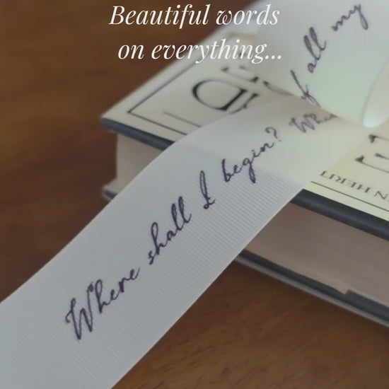 Books with decorative literary quote ribbons and cards on a wooden surface